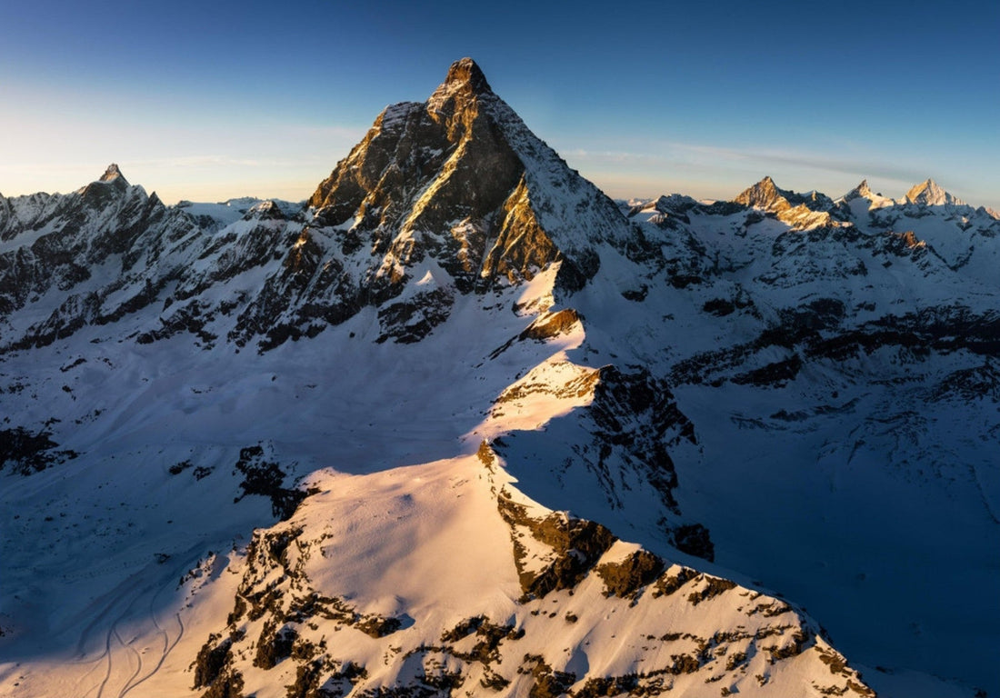 Tableau photo d’un sommet alpin éclairé par les dernières lueurs