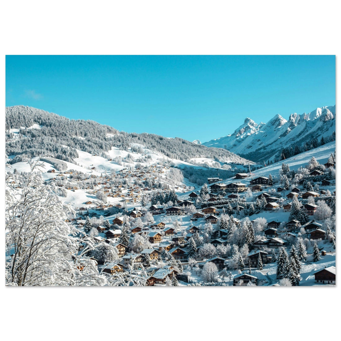 Village de La Clusaz enneigé, son clocher et les crêtes des Aravis en Haute-Savoie