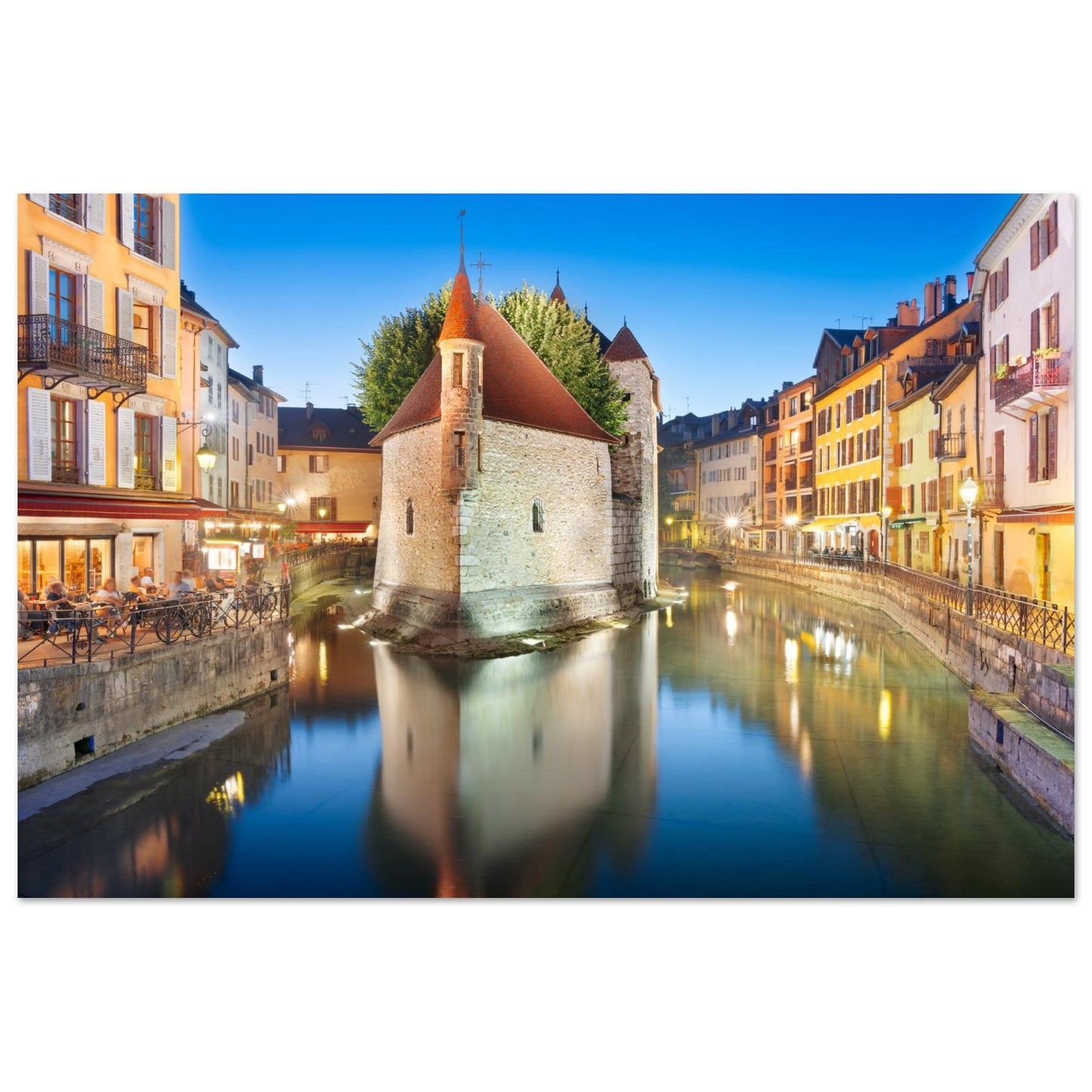 Tableau « Palais de l’Île illuminé au crépuscule dans la vieille ville d’Annecy » dans un intérieur contemporain – simulation 50 × 70 cm