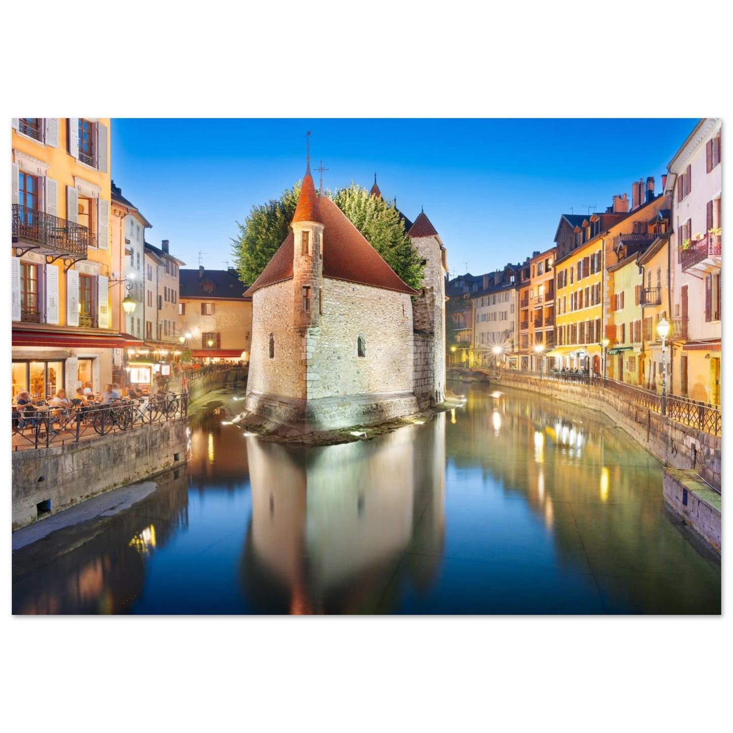 Tableau « Palais de l’Île illuminé au crépuscule dans la vieille ville d’Annecy » dans une chambre contemporaine – simulation 50 × 70 cm
