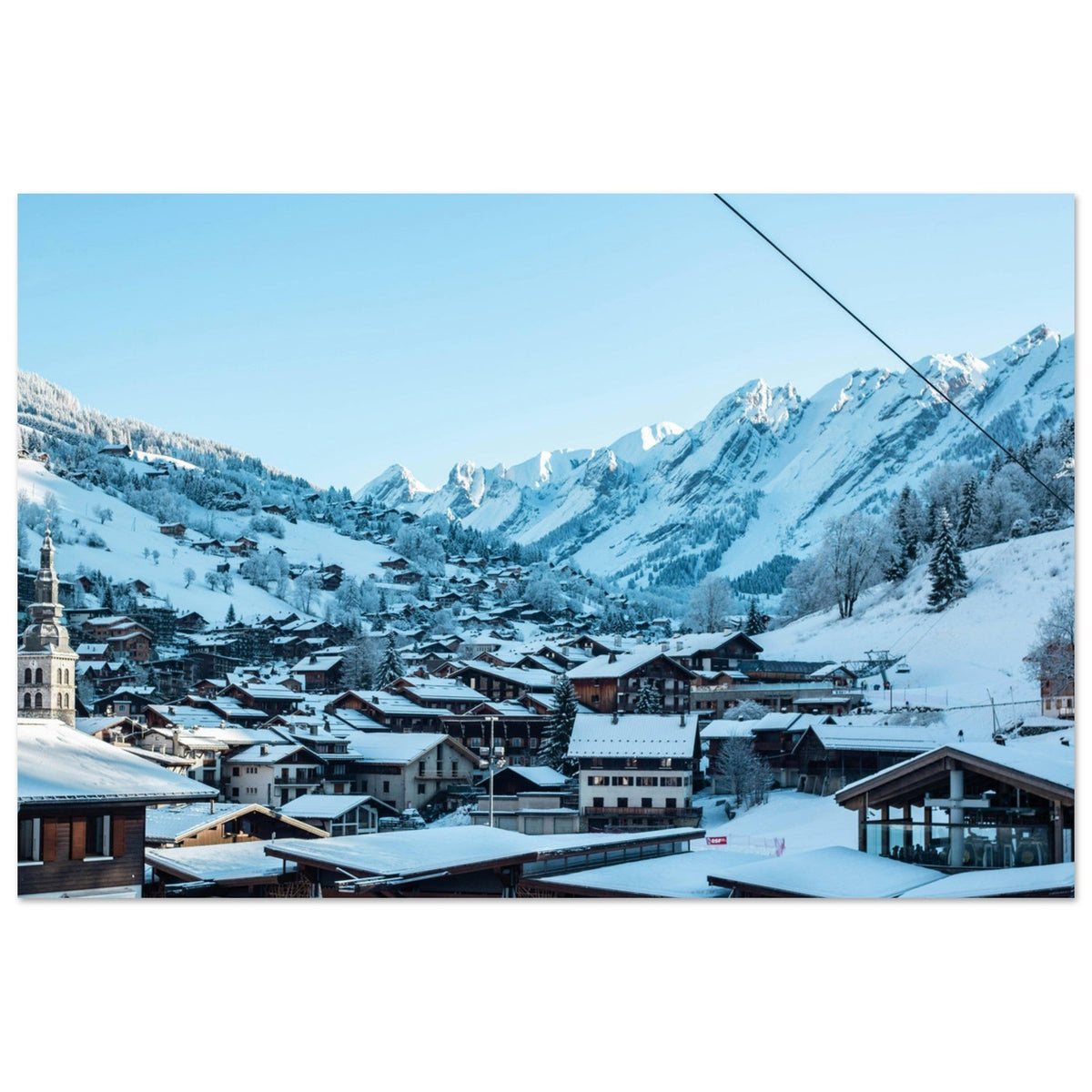 Village de La Clusaz enneigé, son clocher et les crêtes des Aravis en Haute-Savoie