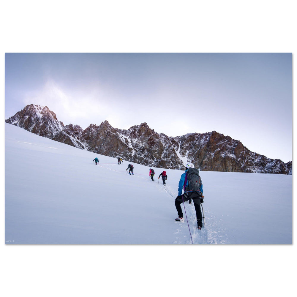 Alpinistes progressant au pied de l’arête des Lanchette dans les premières lueurs